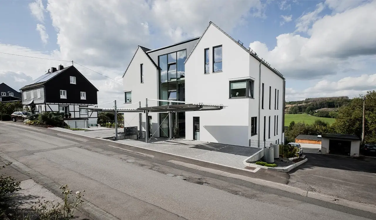 Straßenseite des Atriumhauses mit Carportdach und verglaster Fuge zwischen den beiden Häusern