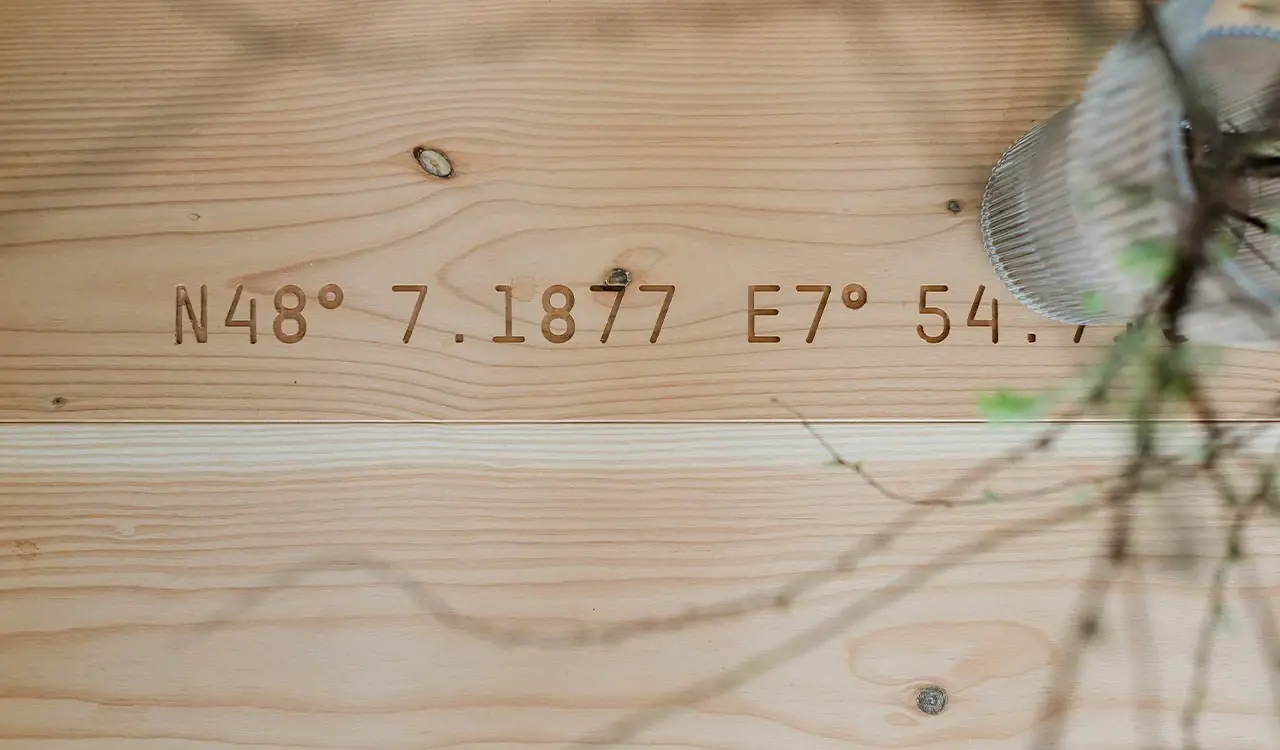 Holzdetail mit eingravierten Koordinaten