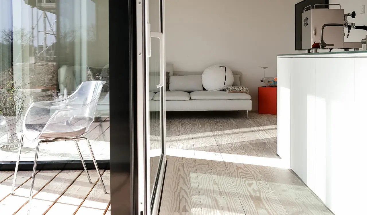 Wohnraum mit Glasschiebetür, Sofa und Blick auf die Terrasse